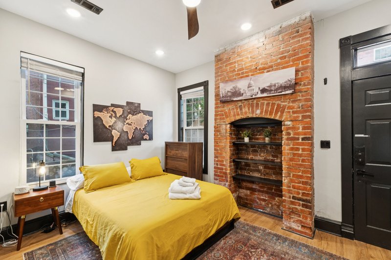 Queen bedroom with exposed-brick fireplace